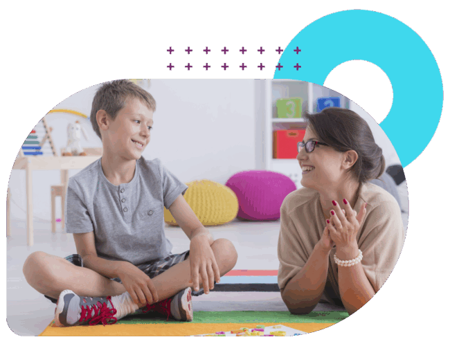 Speech-language therapist and boy sitting on a rug